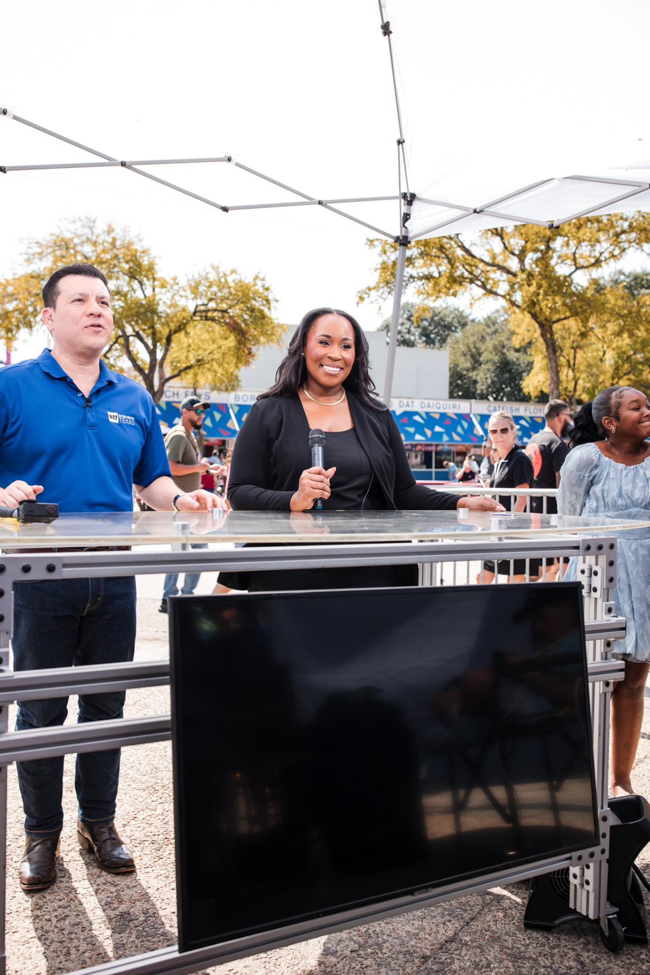 Jennifer Allen hosting a live outdoor television segment with a microphone